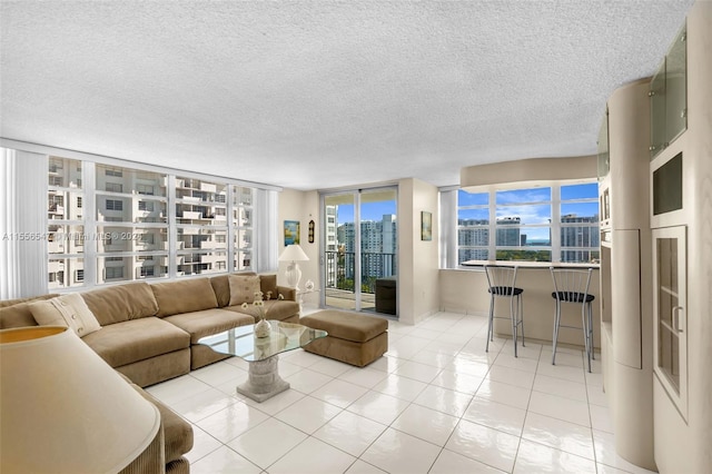 living room featuring light tile patterned flooring, a textured ceiling, and floor to ceiling windows