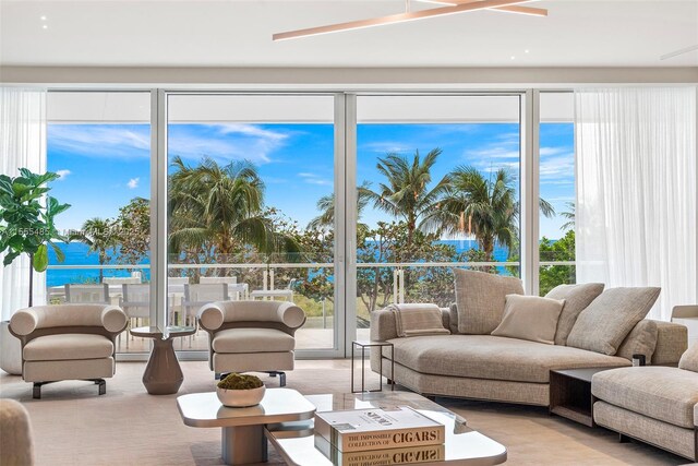 living room with a water view and ceiling fan