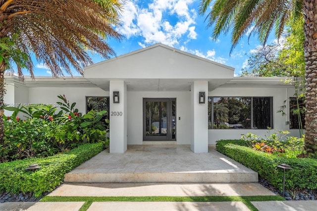 view of exterior entry featuring covered porch