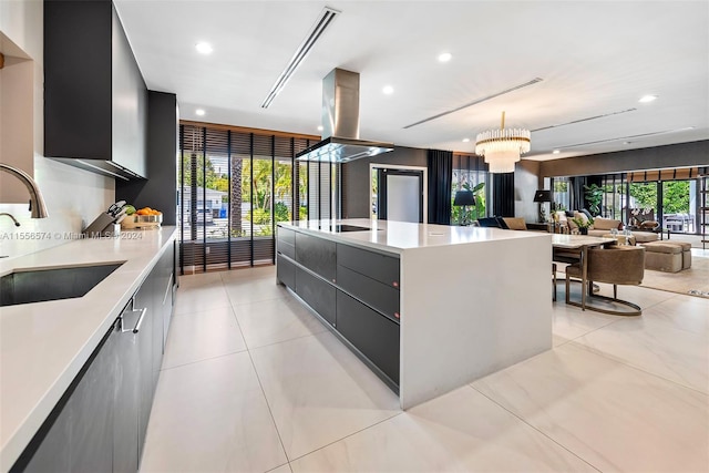 kitchen featuring a large island, island exhaust hood, light tile patterned floors, pendant lighting, and sink