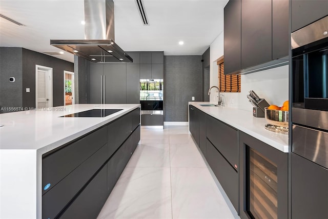 kitchen featuring black electric stovetop, sink, double oven, wine cooler, and exhaust hood