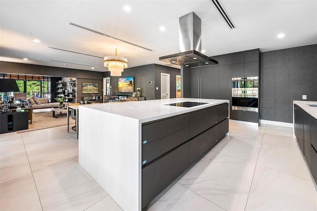 kitchen with island exhaust hood, black electric cooktop, a large island, pendant lighting, and a chandelier