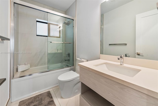 full bathroom featuring vanity, toilet, tile patterned floors, and bath / shower combo with glass door