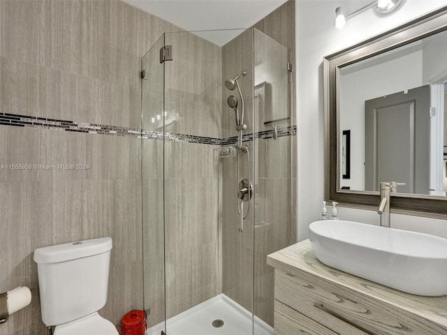 bathroom with oversized vanity, toilet, and tiled shower