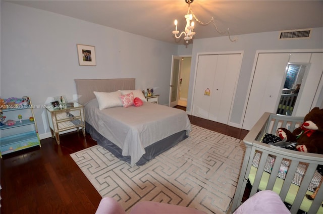 bedroom featuring dark hardwood / wood-style floors and a notable chandelier