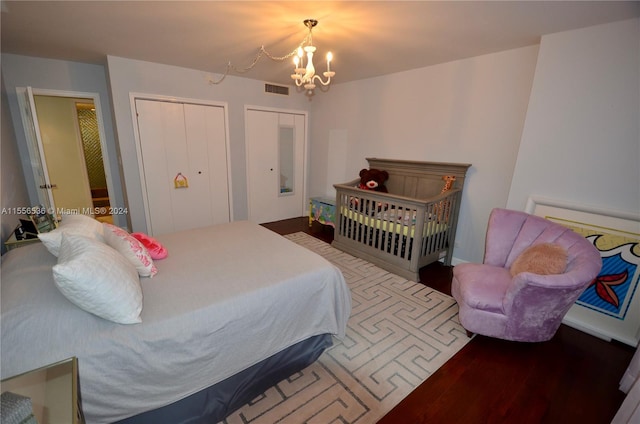 bedroom with an inviting chandelier and hardwood / wood-style floors