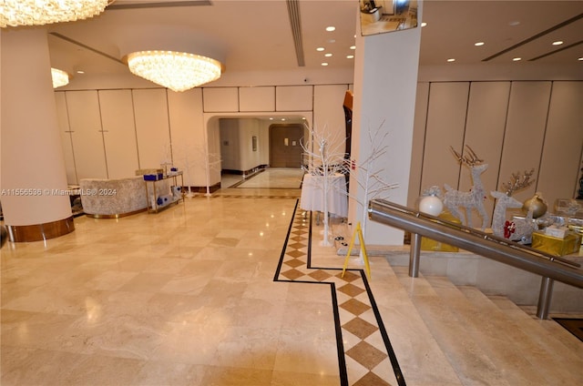 interior space featuring light tile floors, white cabinets, and a chandelier