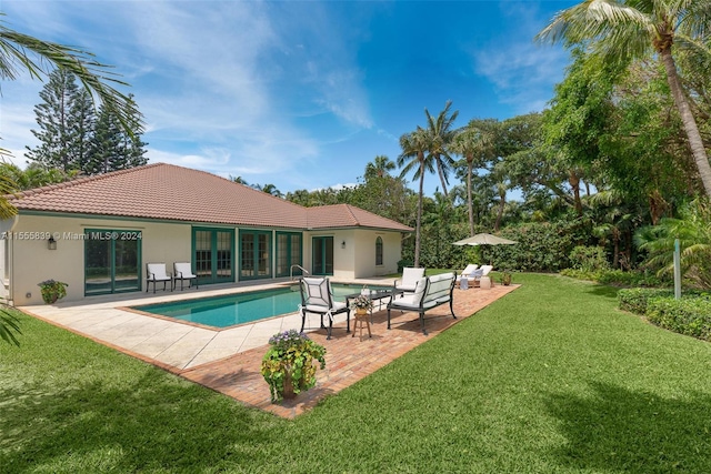 view of pool featuring a lawn, an outdoor hangout area, and a patio area