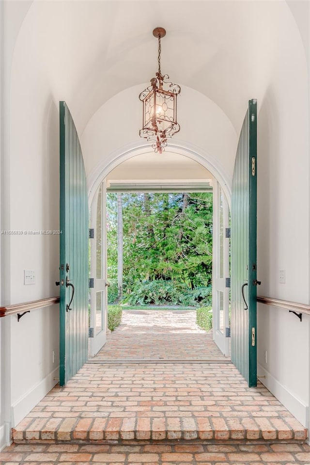 foyer with vaulted ceiling and an inviting chandelier