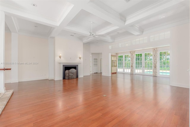 unfurnished living room featuring ceiling fan, light hardwood / wood-style flooring, beam ceiling, and coffered ceiling