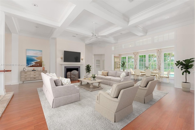 living room with light wood-type flooring, coffered ceiling, beam ceiling, and ceiling fan