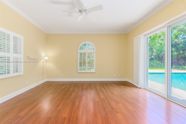 empty room with light wood-type flooring, crown molding, and plenty of natural light