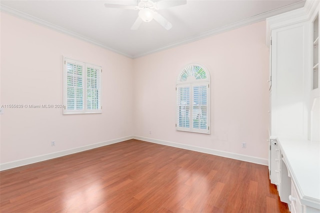 empty room featuring ceiling fan, light wood-type flooring, crown molding, and a wealth of natural light