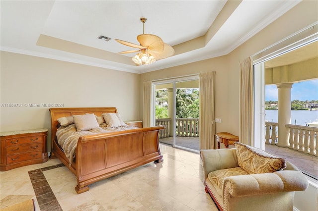 bedroom with light tile floors, access to outside, a tray ceiling, and a water view