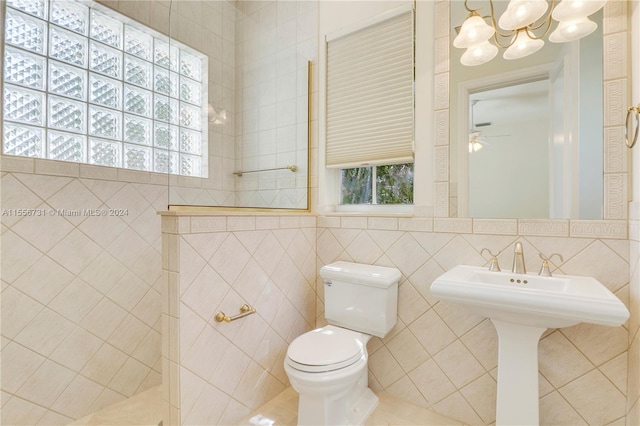 bathroom with tile walls, ceiling fan, and toilet