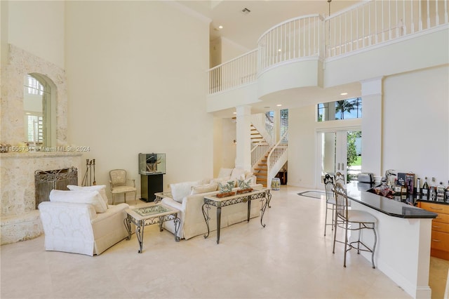 living room with light tile floors, a high ceiling, and french doors