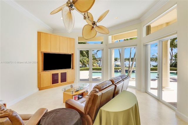 living room featuring light tile floors, ornamental molding, ceiling fan, and a wealth of natural light