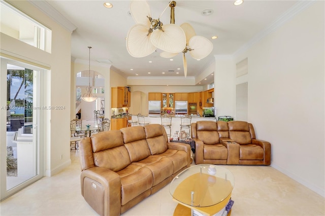 living room featuring a raised ceiling, crown molding, and ceiling fan