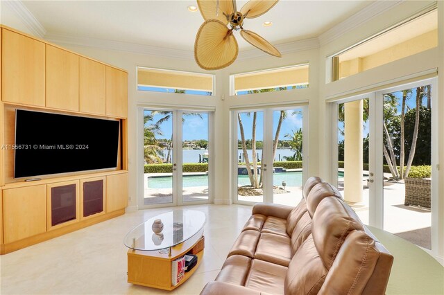 tiled living room featuring a water view, ceiling fan, french doors, and crown molding