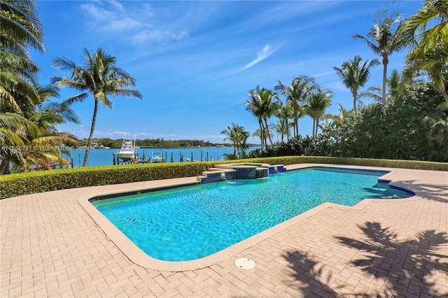 view of swimming pool featuring a water view and a patio area