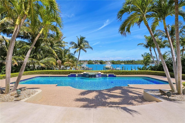 view of pool with a water view and a patio area