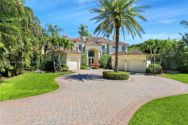 mediterranean / spanish-style home with a front lawn and a garage