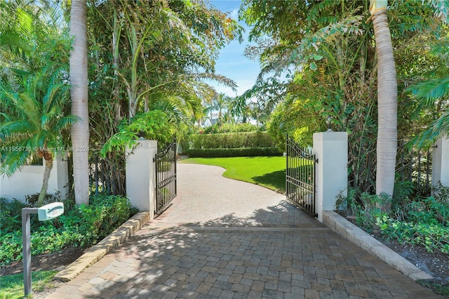 view of gate with a lawn