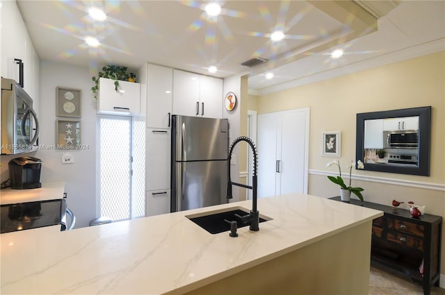 kitchen featuring white cabinetry, light stone countertops, sink, and appliances with stainless steel finishes