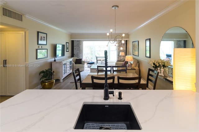 interior space with light stone counters, dark wood-type flooring, sink, decorative light fixtures, and a chandelier