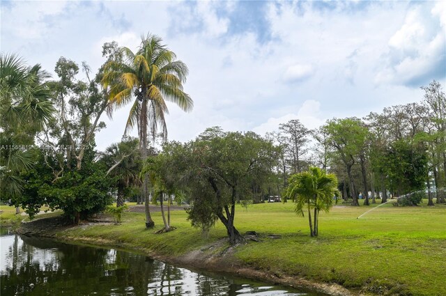 view of home's community with a yard and a water view