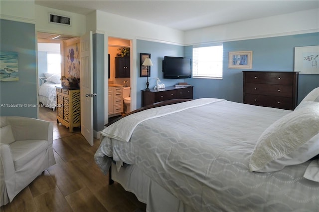 bedroom with dark hardwood / wood-style floors, a spacious closet, connected bathroom, and a closet