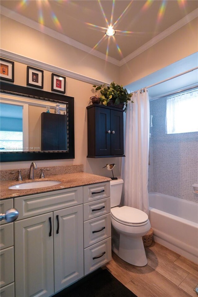 full bathroom with hardwood / wood-style floors, plenty of natural light, crown molding, and shower / tub combo