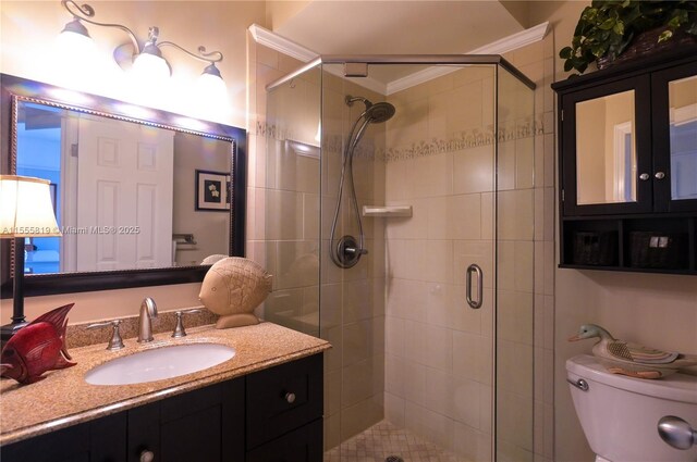 bathroom with a shower with shower door, toilet, ornamental molding, and vanity