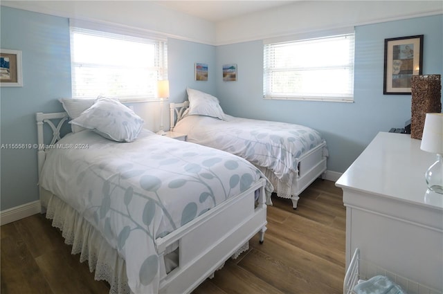 bedroom with dark hardwood / wood-style flooring and multiple windows