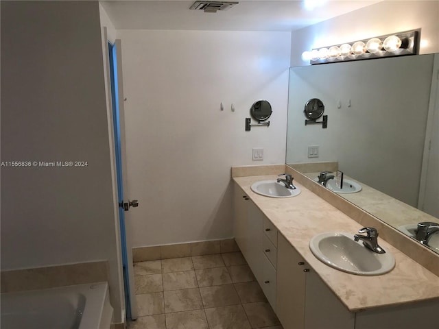 bathroom featuring a bath to relax in, tile floors, dual sinks, and vanity with extensive cabinet space