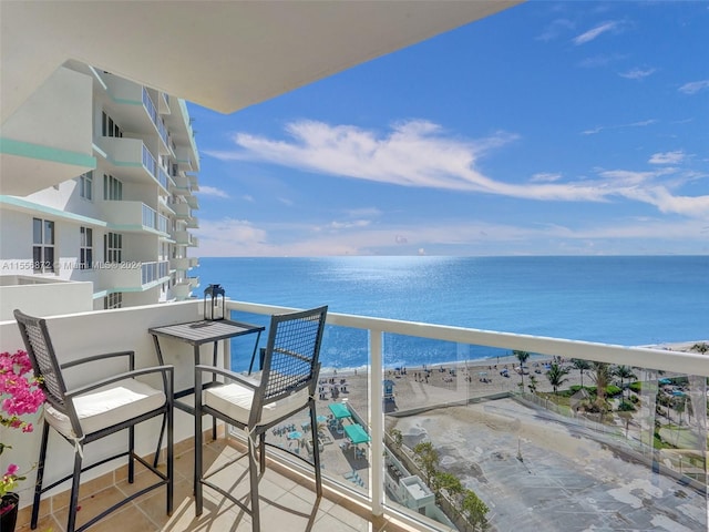 balcony featuring a view of the beach and a water view