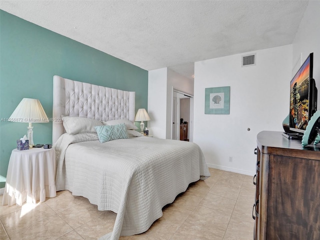 tiled bedroom with a closet and a textured ceiling