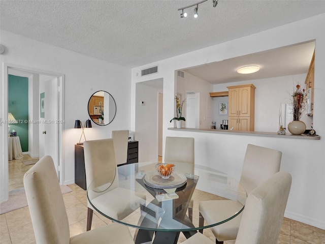 tiled dining room with a textured ceiling