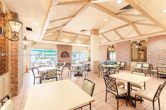 dining area featuring light tile patterned floors, a textured ceiling, brick wall, and a fireplace