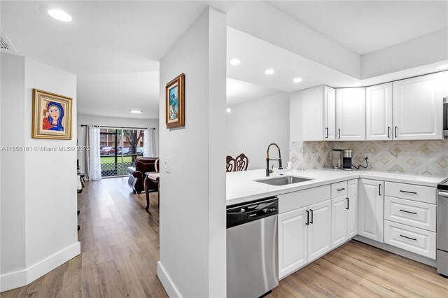 kitchen featuring stainless steel appliances, light wood-type flooring, sink, and white cabinetry