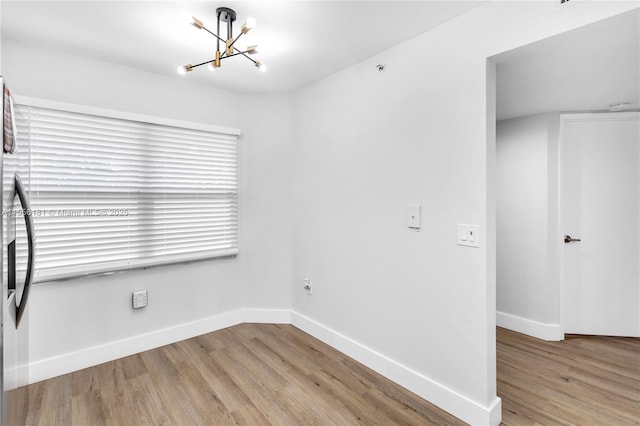 701 SW 142nd Ave Unit 108S, Pembroke Pines, FL 33027 - unfurnished room with a chandelier, light wood-style floors, and baseboards