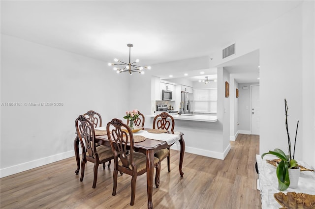 701 SW 142nd Ave Unit 108S, Pembroke Pines, FL 33027 - dining space with a chandelier, light wood finished floors, and baseboards