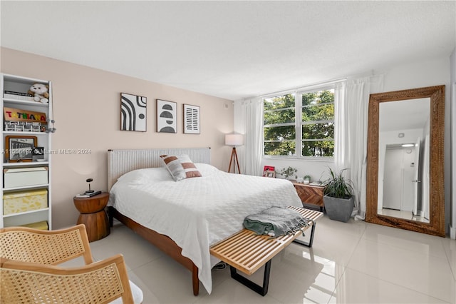 bedroom with a textured ceiling and light tile flooring