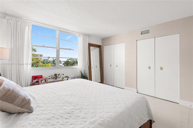 bedroom with multiple closets and a textured ceiling