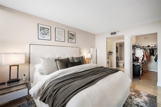 bedroom with a closet, a spacious closet, and ensuite bath