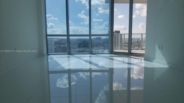 unfurnished room featuring tile floors and expansive windows