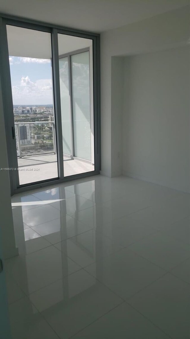 tiled spare room featuring floor to ceiling windows and plenty of natural light