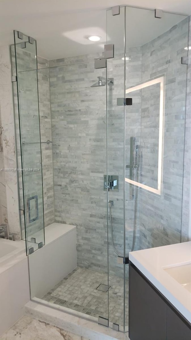 bathroom featuring tile flooring, separate shower and tub, tile walls, and vanity