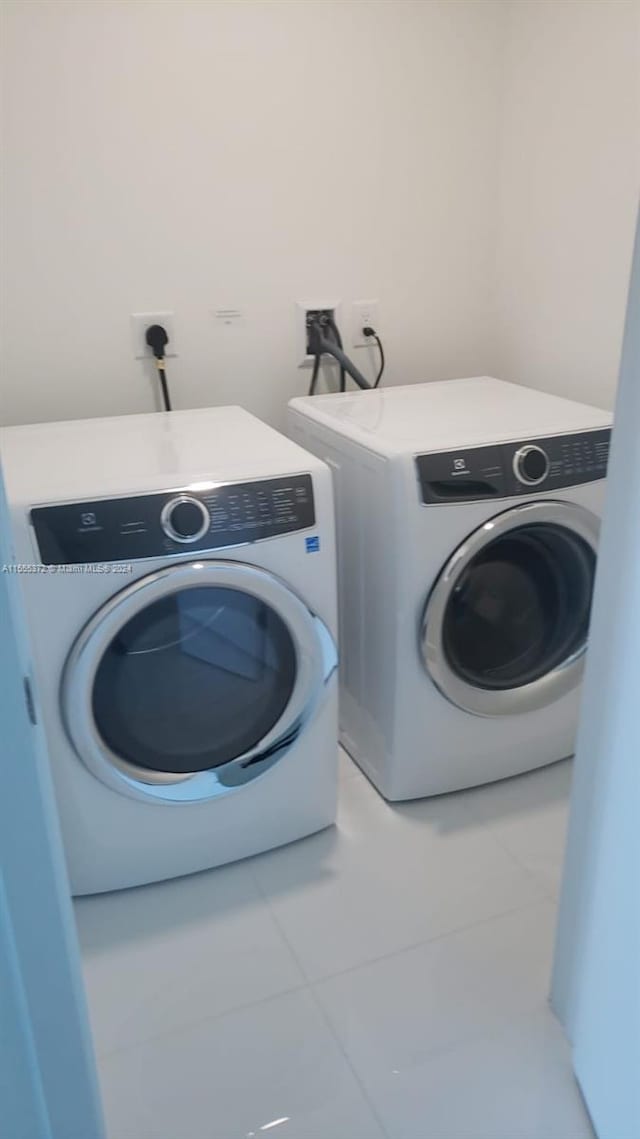 clothes washing area featuring washer and dryer, tile floors, washer hookup, and electric dryer hookup