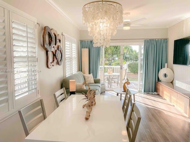 dining area featuring light hardwood / wood-style floors, ornamental molding, and ceiling fan with notable chandelier